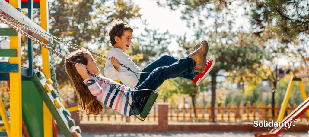 Children swinging on playset.